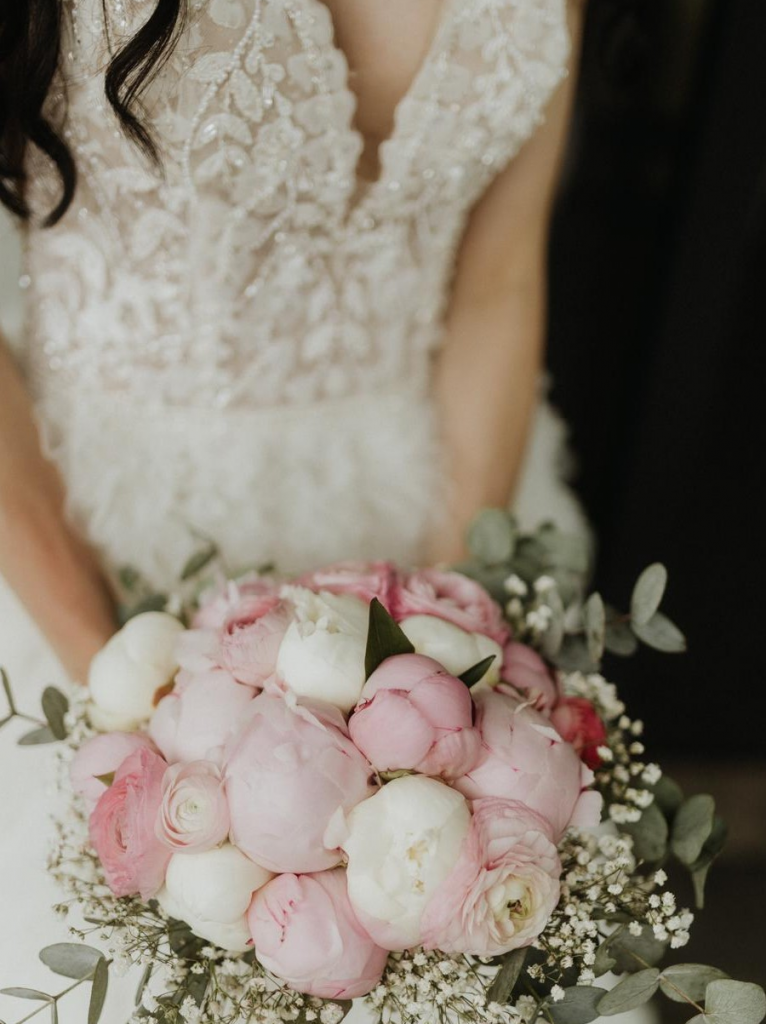 Das Brautpaar - eine Nah-Aufnahme der Braut, die ihren Brautstrauß hält.