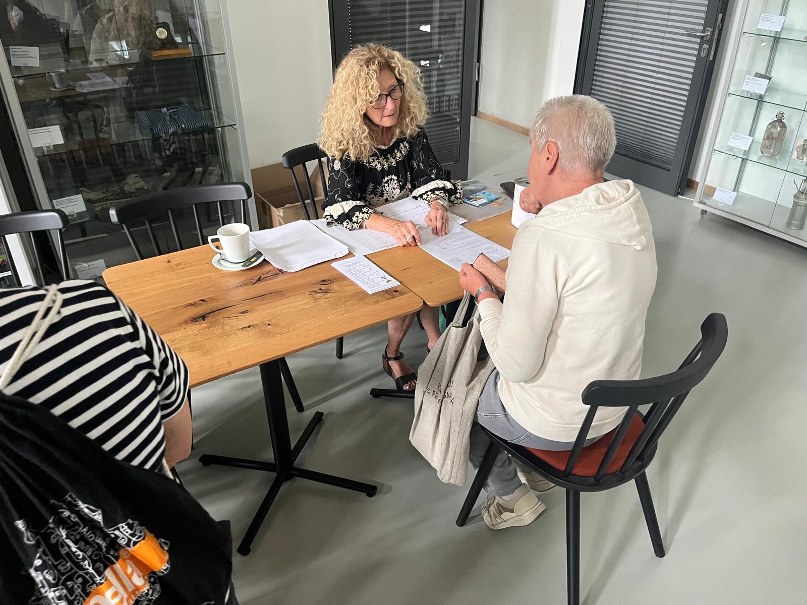 Eine der Seniorinnen meldet sich bei der Seniorentafel an.