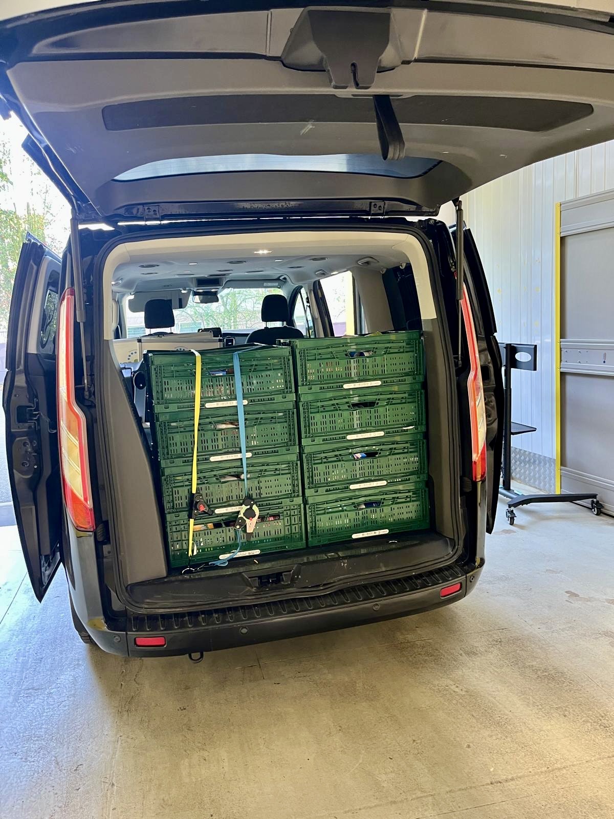 Der Kofferraum unseres schwarzen Lieferbusses ist randvoll mit Spenden-Kisten mit Lebensmitteln und Hygieneartikeln.