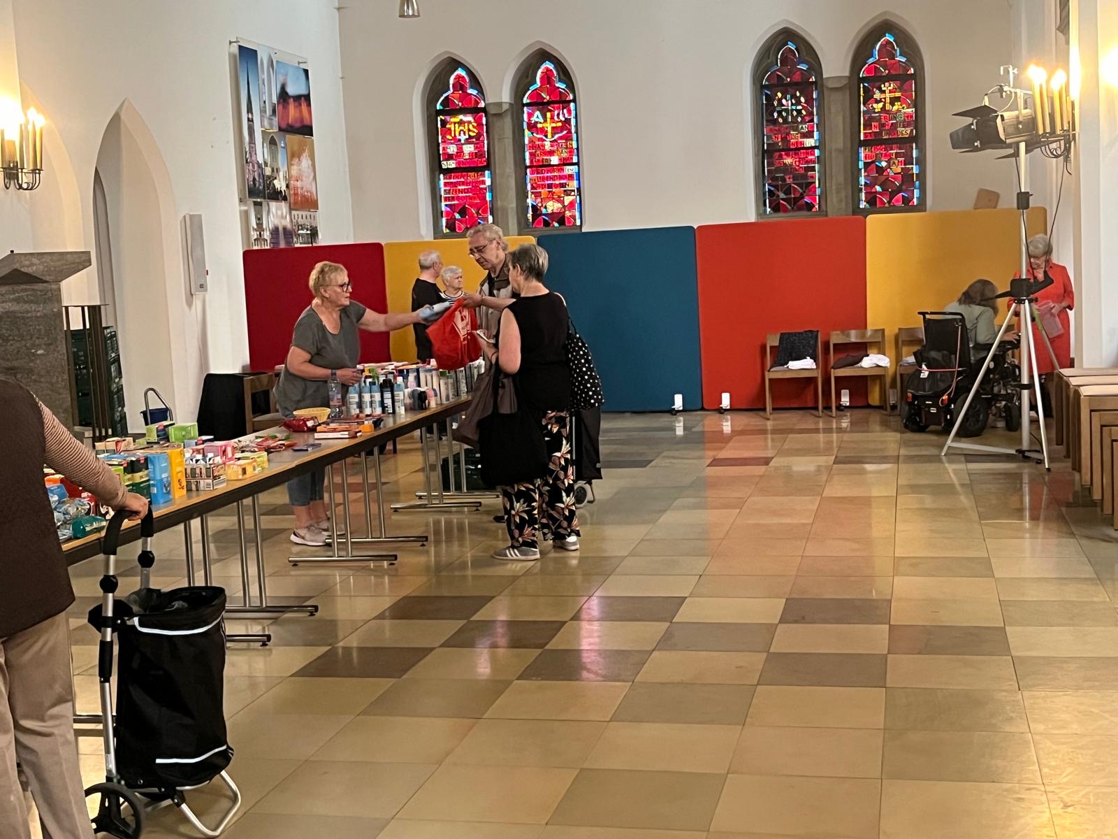 Die Seniorinnen und Senioren decken sich mit haltbaren Lebensmitteln und Hygieneartikeln ein.