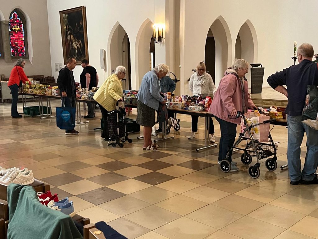 Anstehen an der Seniorentafel - die Seniorinnen und Senioren decken sich reichlich ein.
