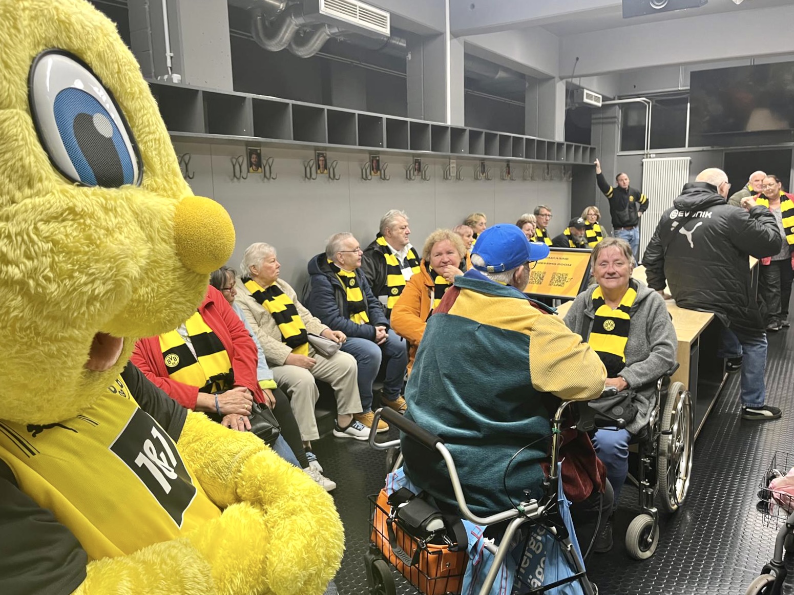 Im Innenraum freuen sich die Zuschauerinnen und Zuschauer auf das Weihnachtssingen. Immer mit dabei - Das BVB-Maskottchen