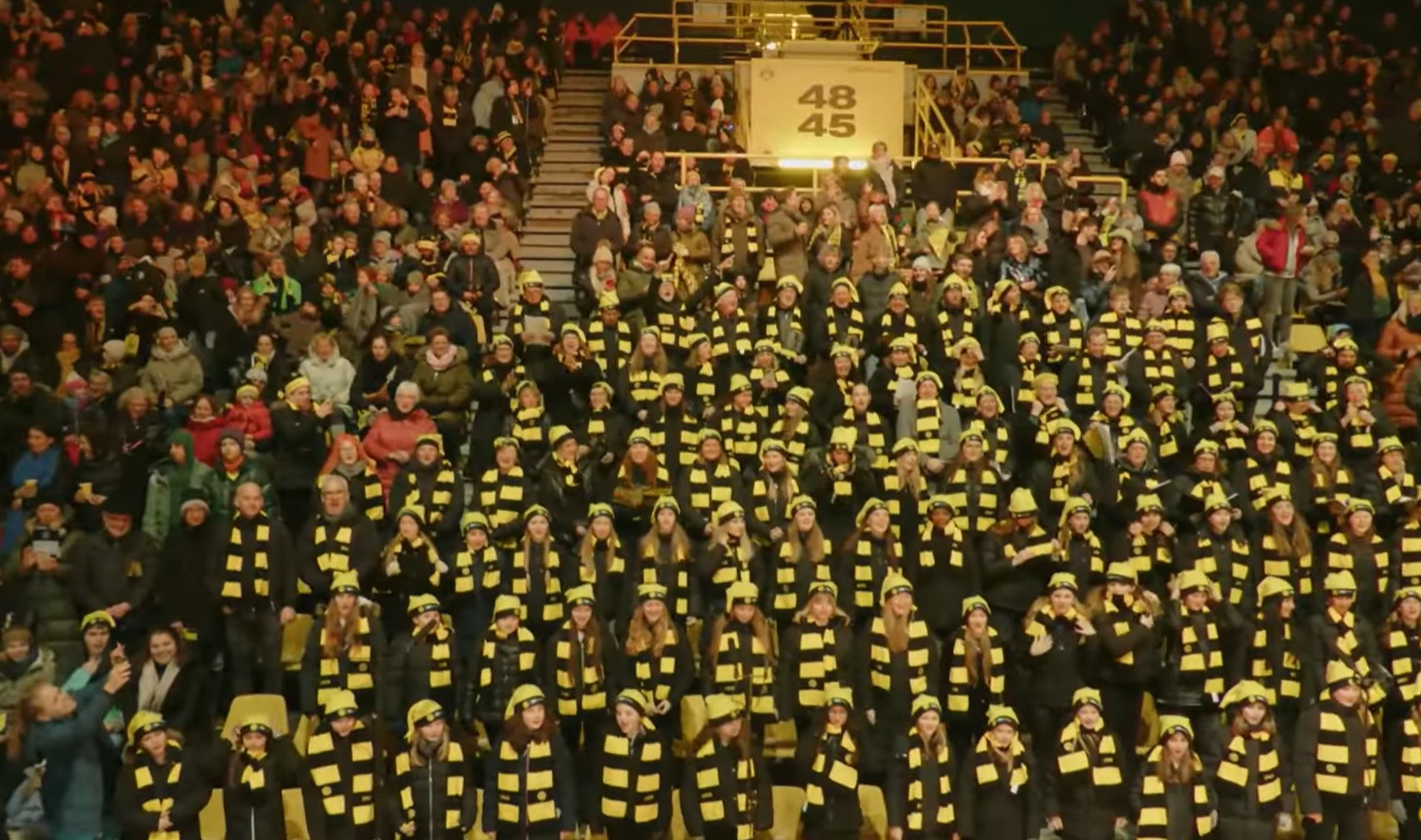 Die Borussen singen - mit gelb-schwarzen Mützen und gelb-schwarz gestreiften Schals haben sich die Sängerinnen und Sänger im Stadion versammelt.