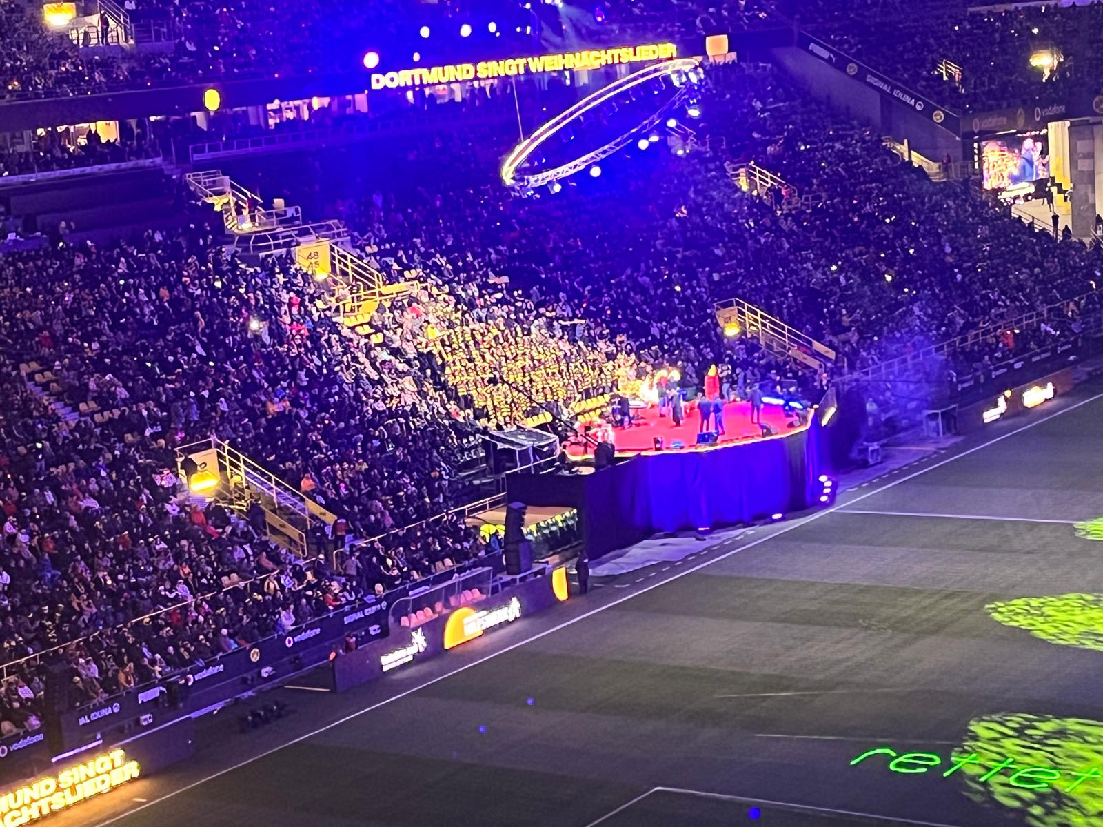 "Dortmund singt Weihnachtslieder" steht in großen hellgelben Buchstaben überall im hell erleuchteten BVB-Stadion, wo am ersten Advent das traditionelle Weihnachtssingen statt fand.