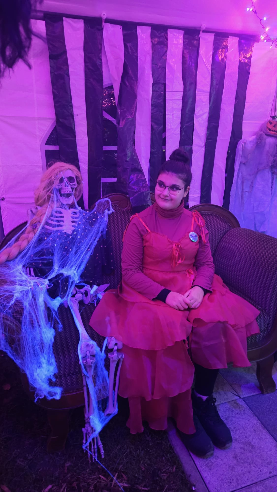 Die Frau in Pink - links neben ihr lacht das Skelett mit blonder Gretchen-Perrücke.