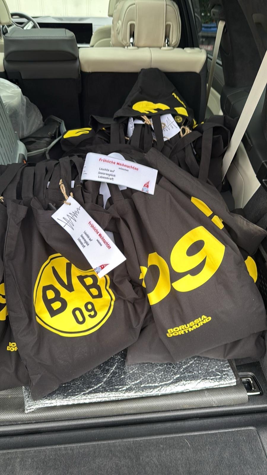"Fröhliche Weihnachten wünschen Leuchte auf!, Seniorenglück, Lebenskraft" steht auf jedem Schild, das an jede der BVB-Taschen geheftet ist, die die Seniorinnen und Senioren nach dem Weihnachtssingen zusätzlich geschenkt bekamen.