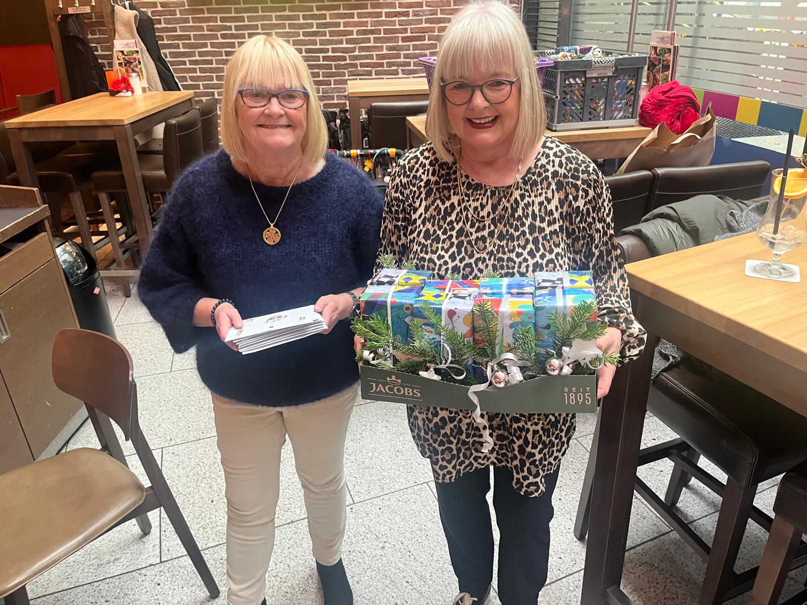 Frau Cornelia Sbosny (rechts) und eine weitere ehrenamtliche Helferin halten die Gutscheine und Geschenke bereit.