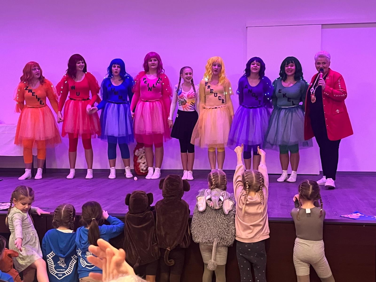 Die Kirchderner Funken zeigen große Gefühle: von links nach rechts: Zweifel in orange, Wut in Rot, Kummer in Blau, Peinlich in Pink, viele bunte Hände, Freude in Gelb, Angst in Lila, Ekel in Blaugrau, ganz rechts: eine der Dortmunder Juwelen.