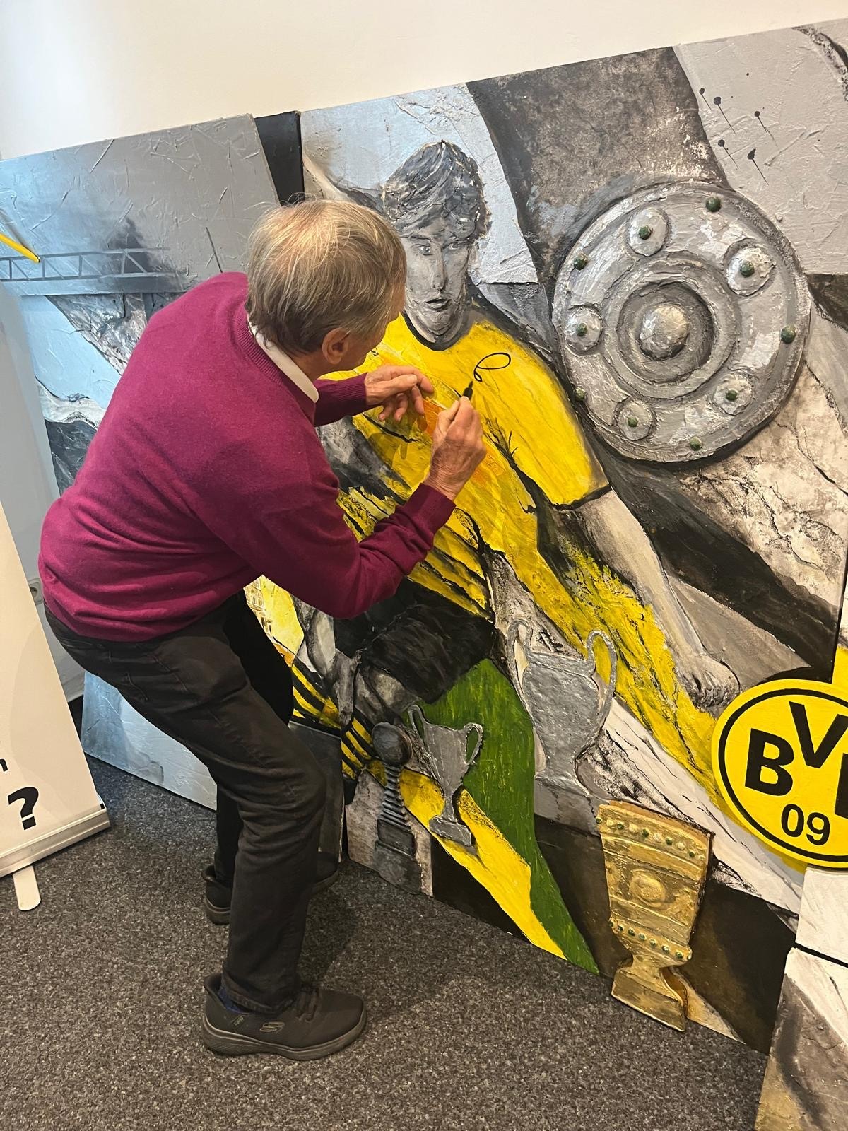 Fußball-Legende Siggi Held signiert das BVB-Wandgemälde.