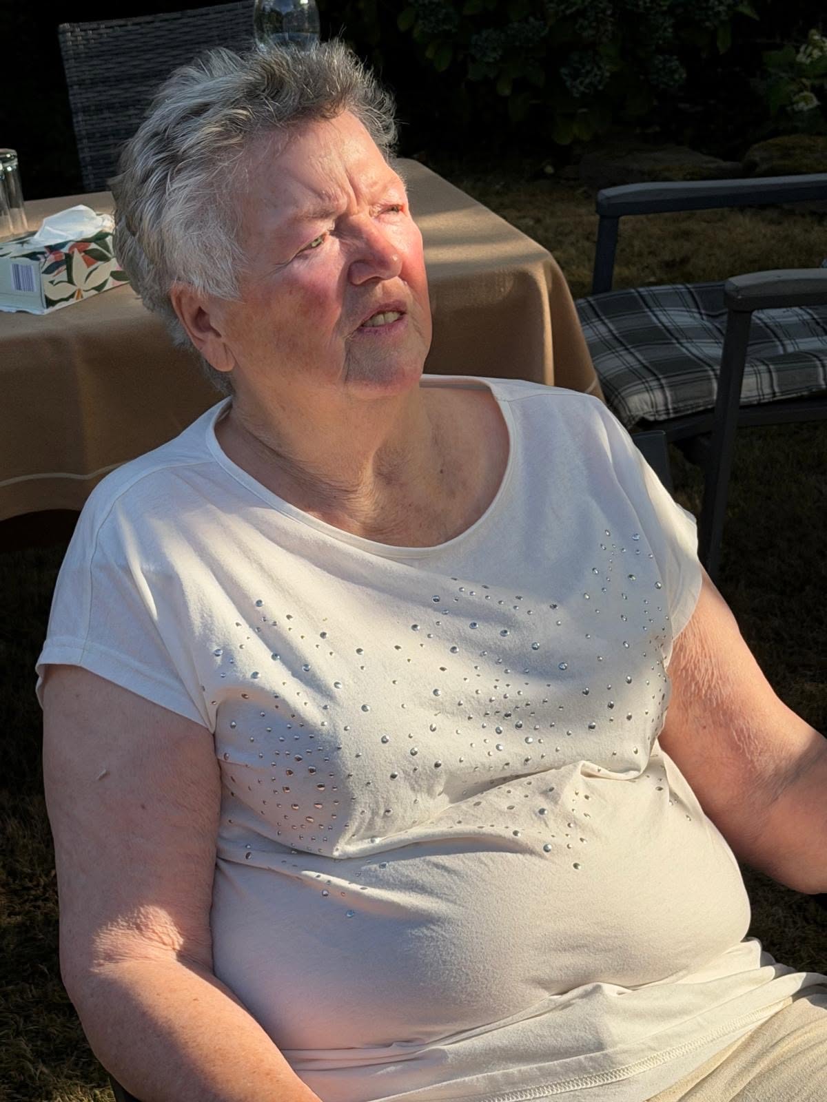 Eine Seniorin lässt sich die Sonne ins Gesicht scheinen.
