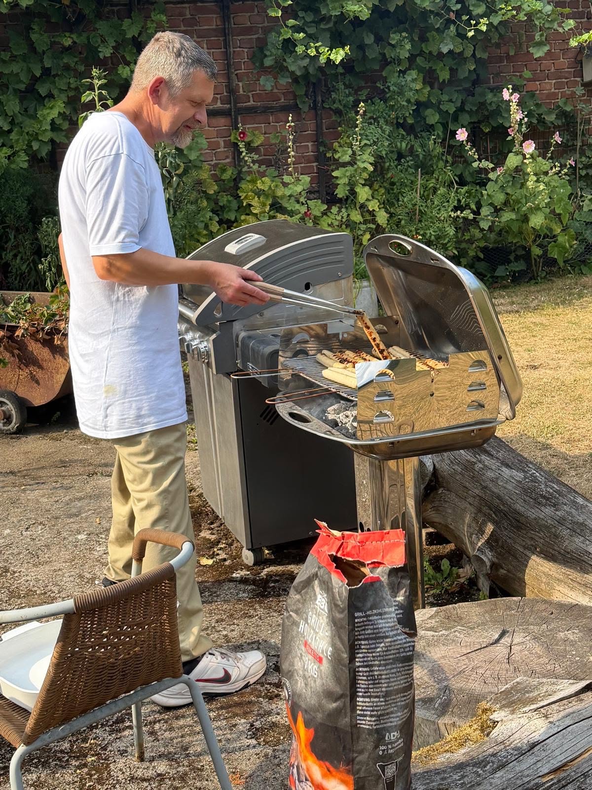 Einer der Senioren steht am Würstchen-Grill.