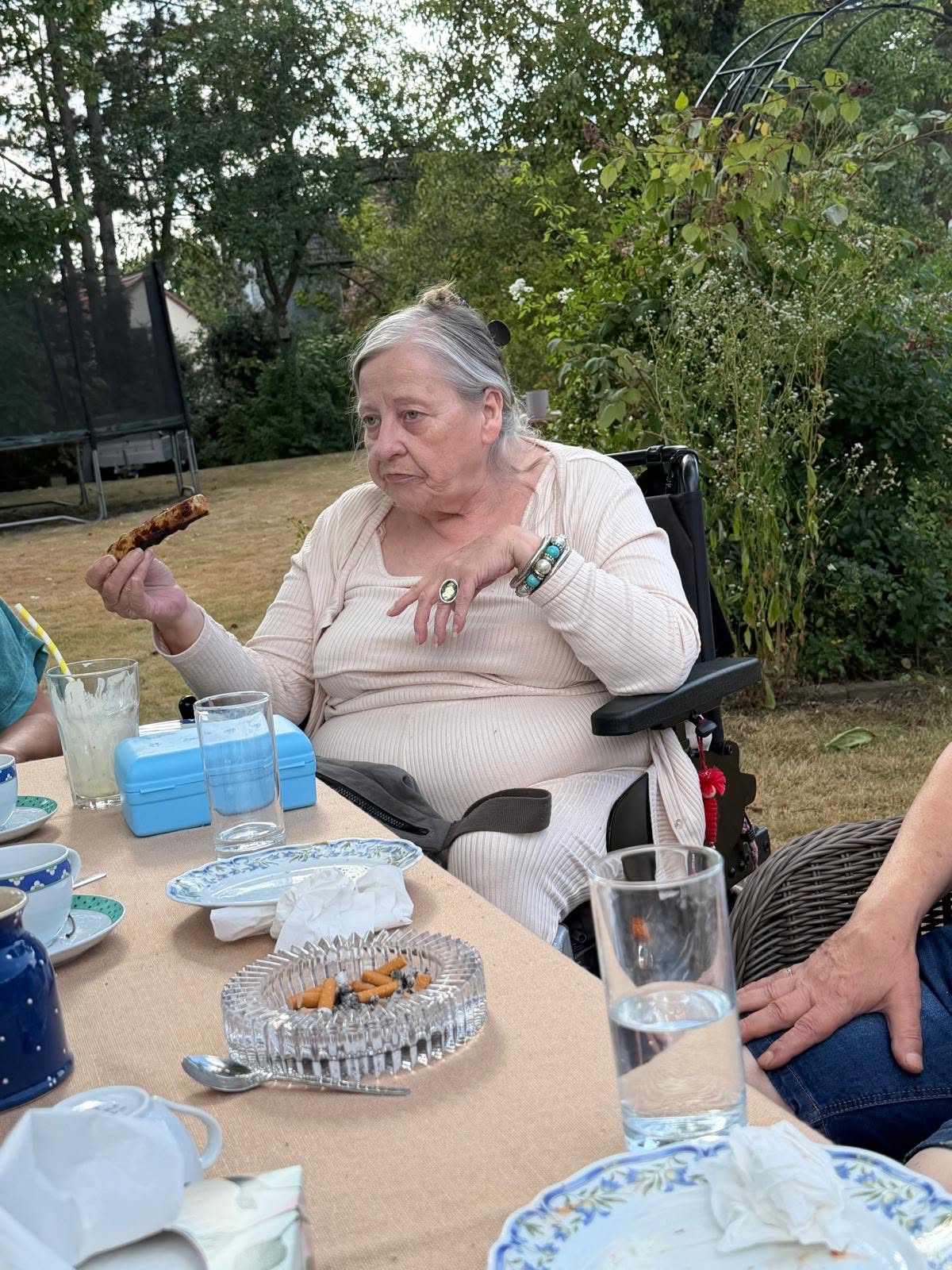 Eine Seniorin genießt eine frisch gegrillte Wurst.