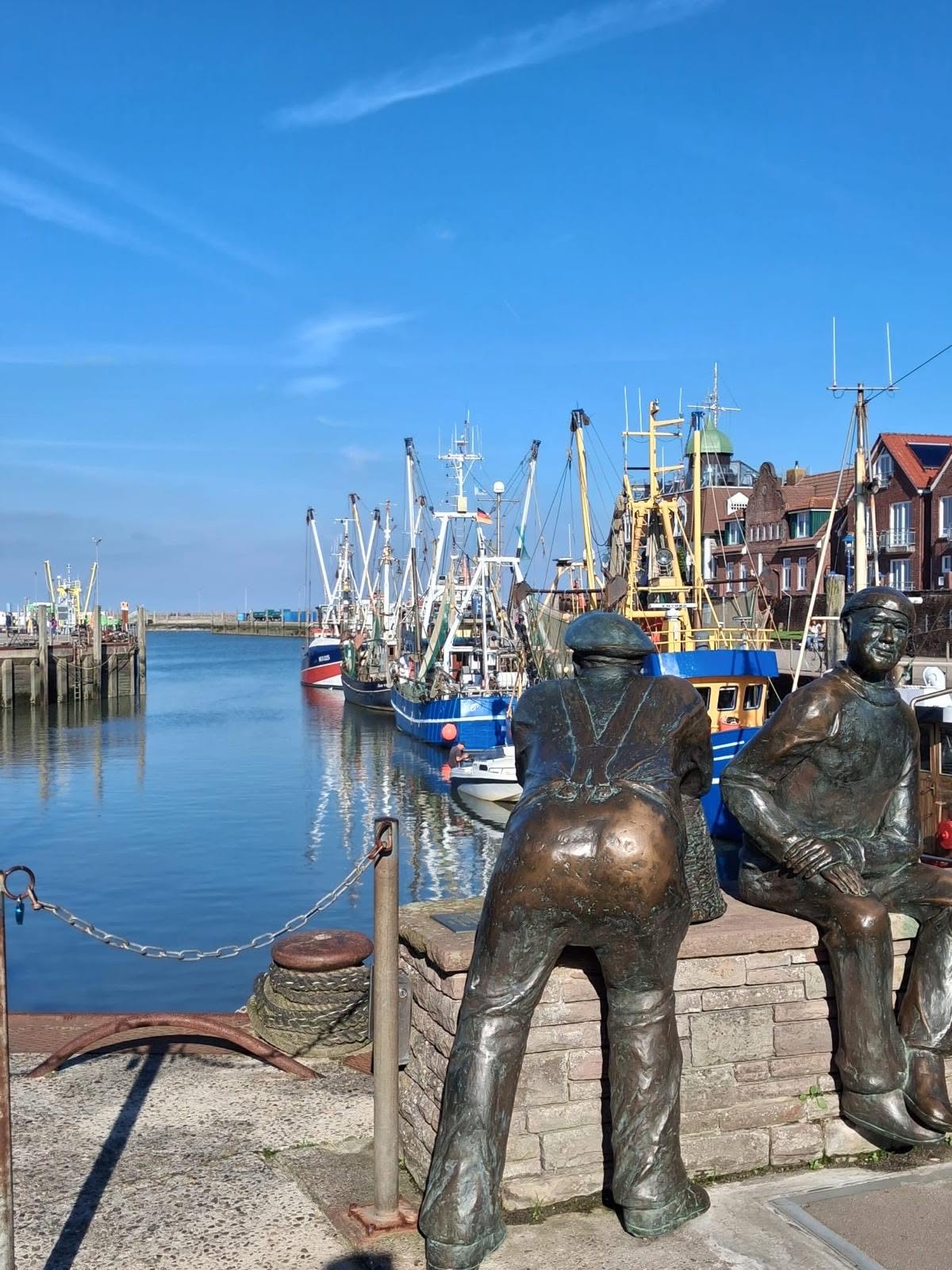 Am Neuharlingersieler Hafen gibt es nicht nur viele Schiffe, sondern auch zwei Seemanns-Statuen aus Kupfer.